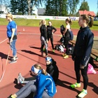 Lotta ja isla (istumassa) ja Emilia T15-sarjan keihäänheitossa